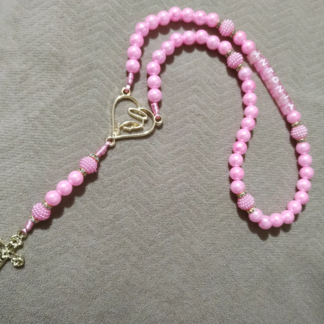Terço rosa com detalhes dourados, peça feita pela Artes da Val